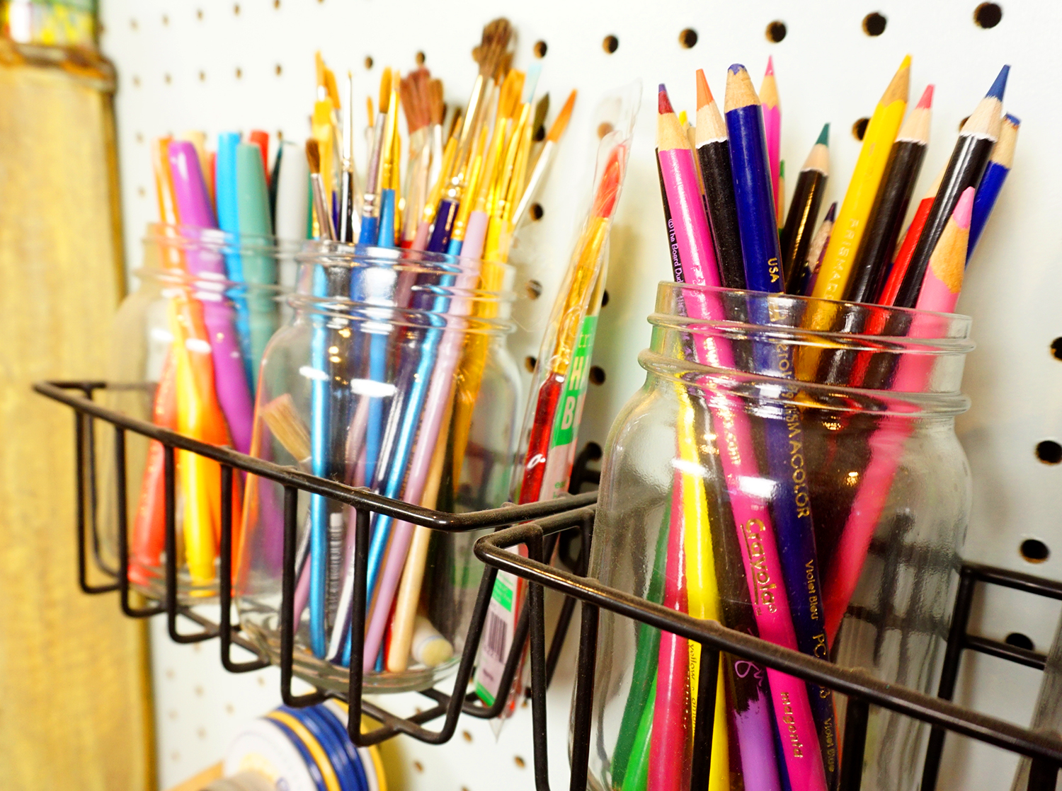 mason jars full of colored pencils and paintbrushes