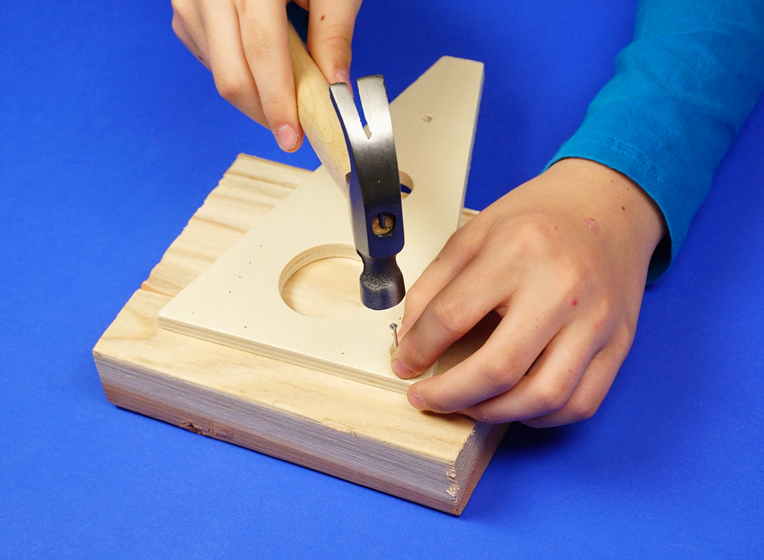 kid nailing pieces together with hammer