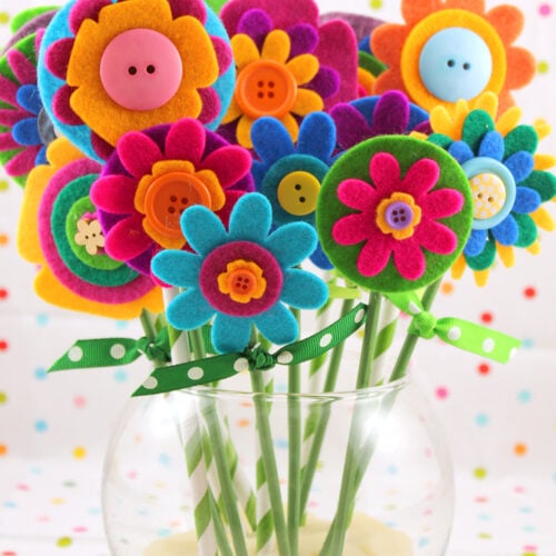 colorful felt flower bouquet in vase on polka dot background