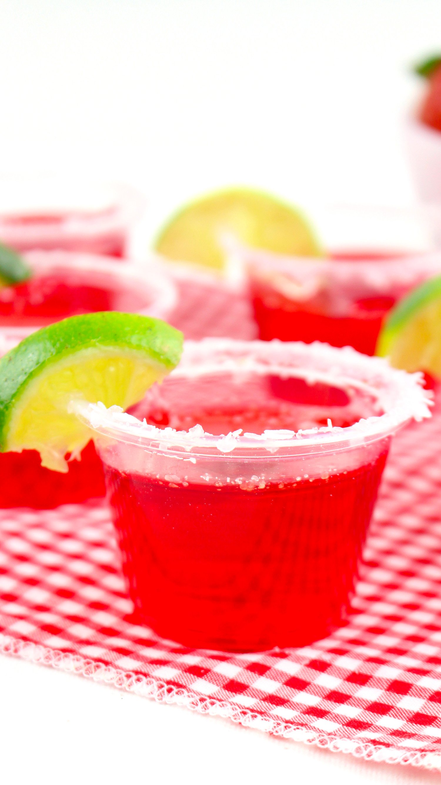 strawberry margarita jello shots with a lime garnish