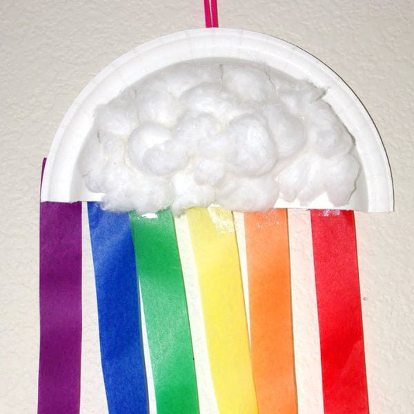 Rainbow kids craft made from a paper plate, cotton balls, and colorful paper streamers