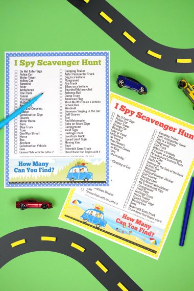 Two road trip "I Spy Scavenger Hunt" printable game cards on green background with road graphic and small toy cars