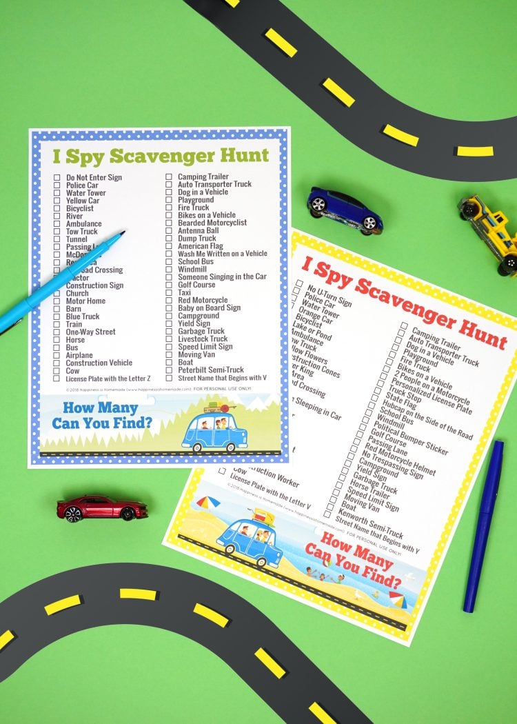 Two road trip "I Spy Scavenger Hunt" printable game cards on green background with road graphic and small toy cars