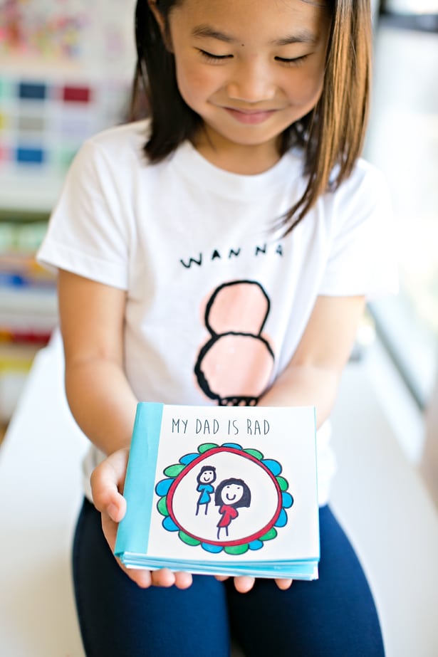 girl holding diy kid made fathers day book 