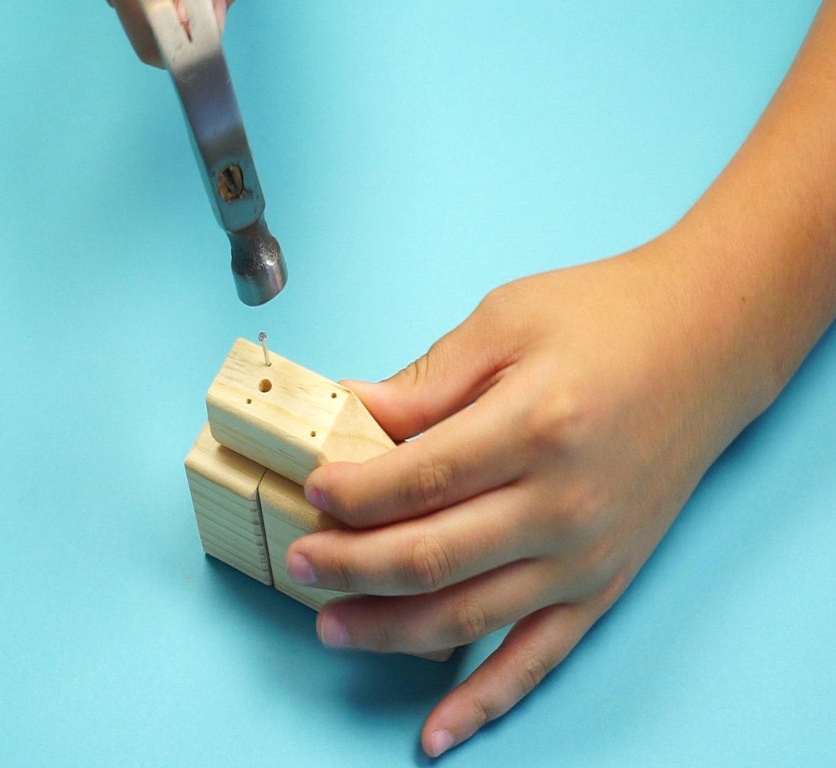 child hammering nail into portion of helicopter project 