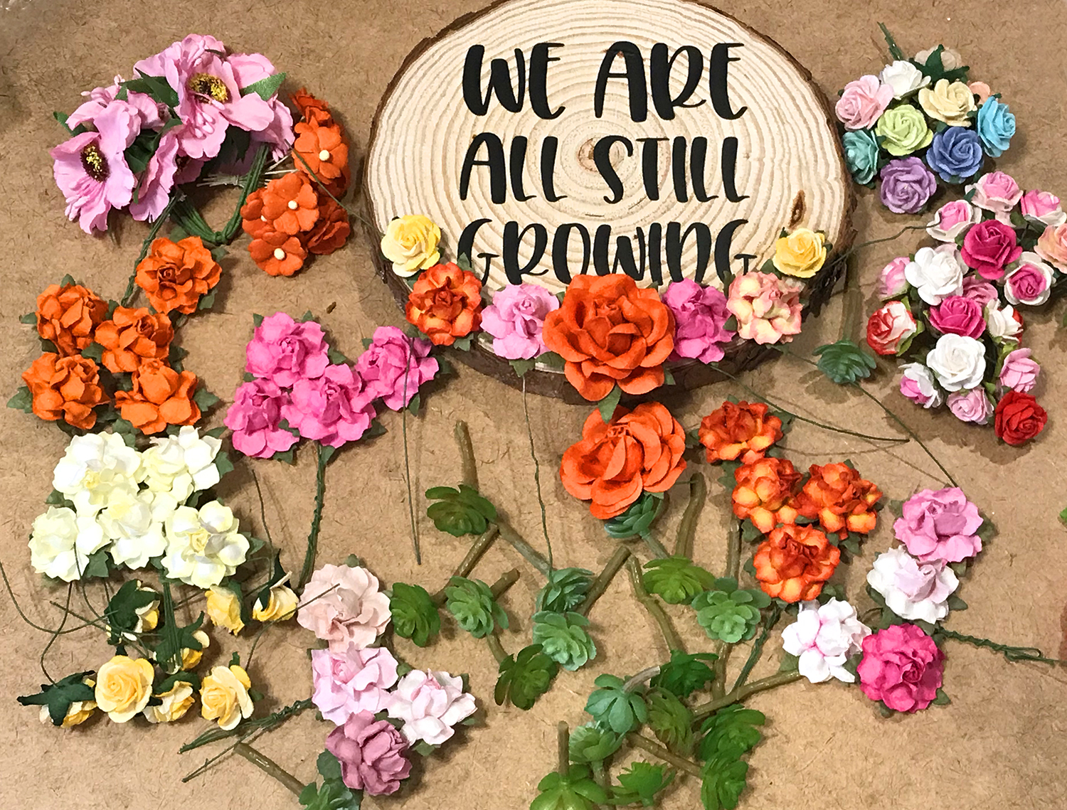 we are still growing vinyl on wood round with fake flowers placed around
