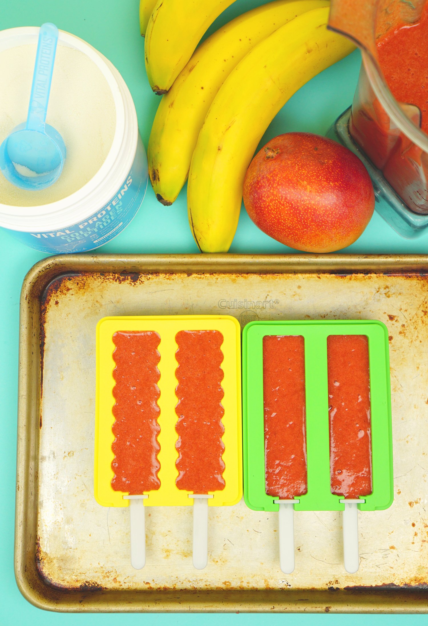 fruit pop mix added into molds on tray with fruit nearby