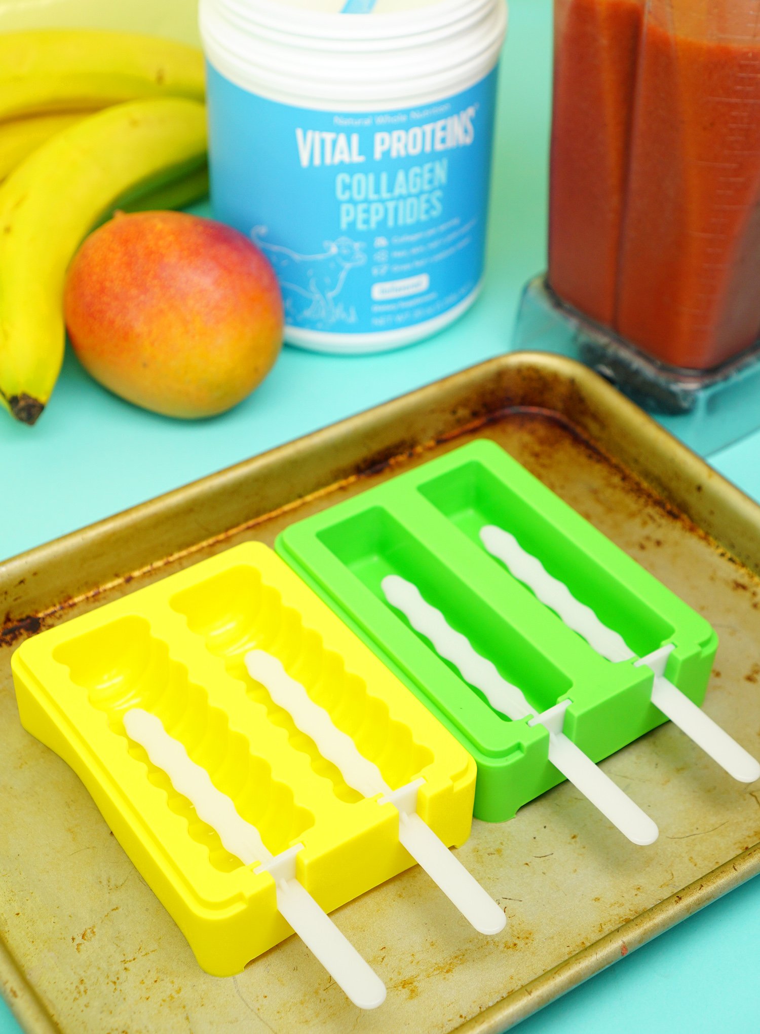 popsicle sticks inserted into freezer pop molds on tray