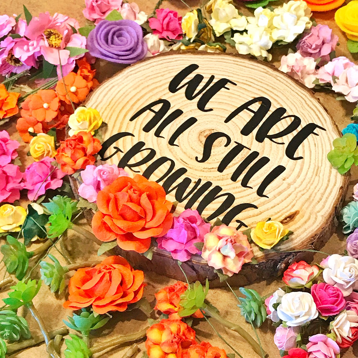 flowers surrounding we are still growing sign