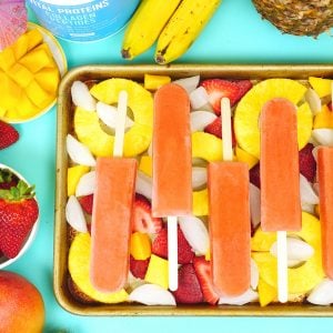 diy tropical smoothie popsicles on tray with ice cubes and fruits
