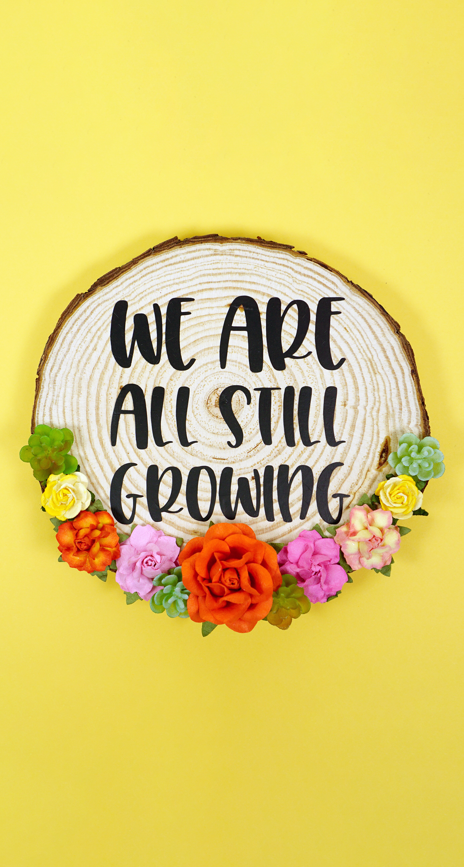we are still growing sign on wood round with flowers