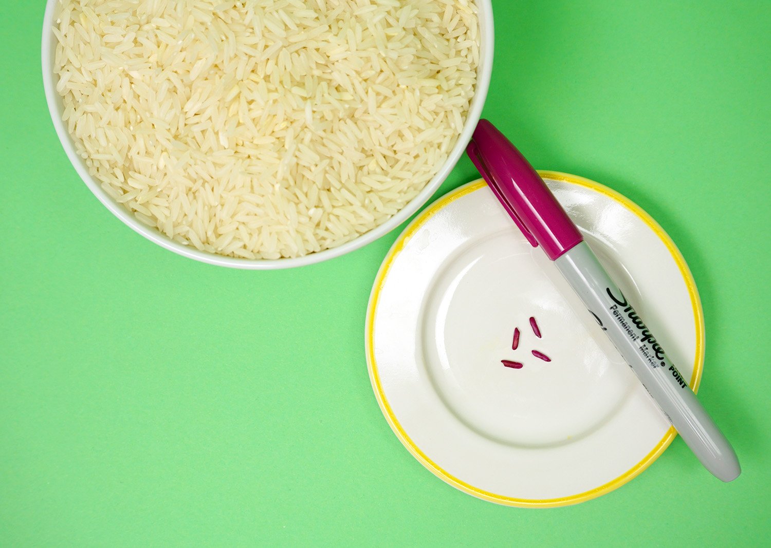 bowl of rice and colored grains of rice with a marker