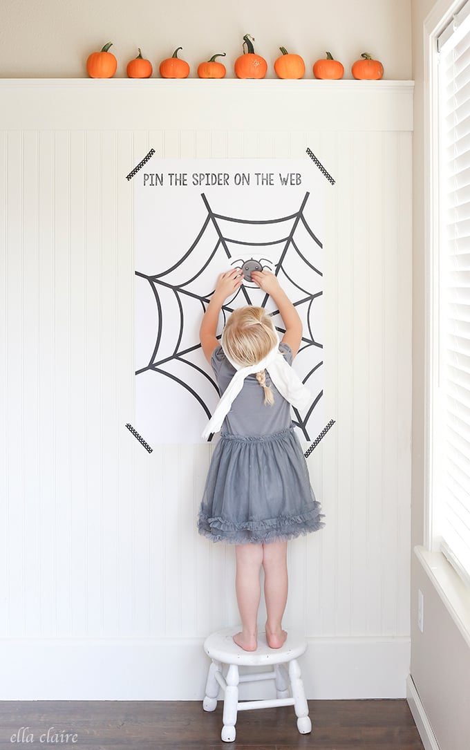 child playing pin the spider on the web game