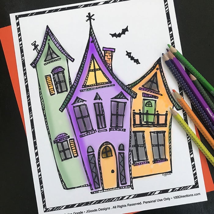 Haunted house coloring page with bats and colored pencils