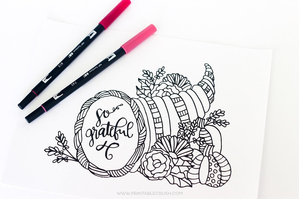 "So grateful" cornucopia Thanksgiving coloring page with two markers on a white background