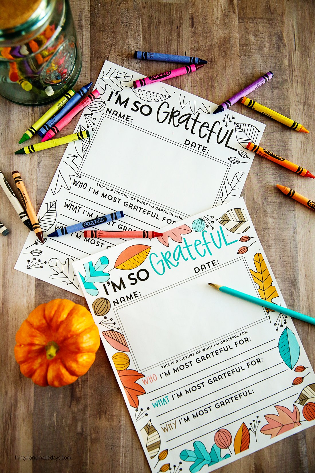 "I'm So Grateful" Thanksgiving coloring page on wood background with crayons and pumpkin
