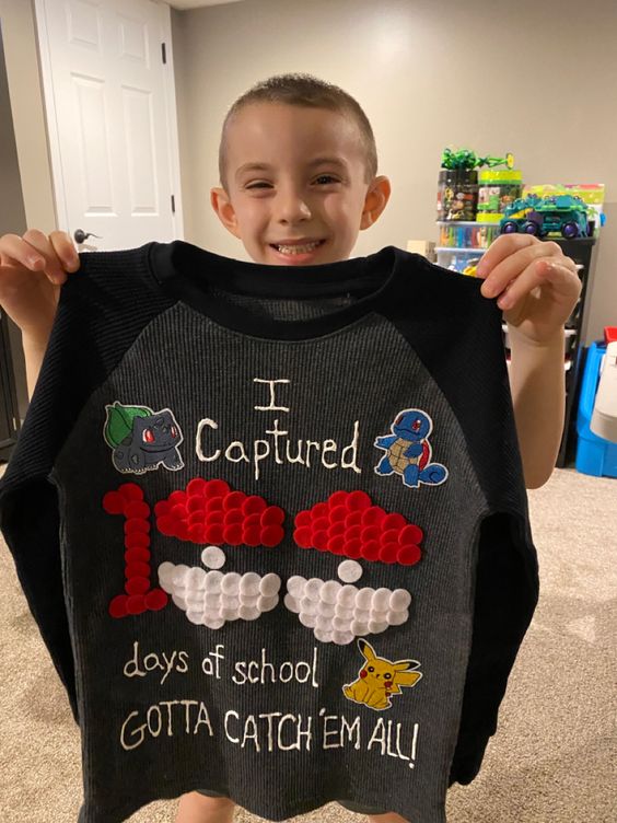 boy holding up pokemon themed 100 days of school shirt
