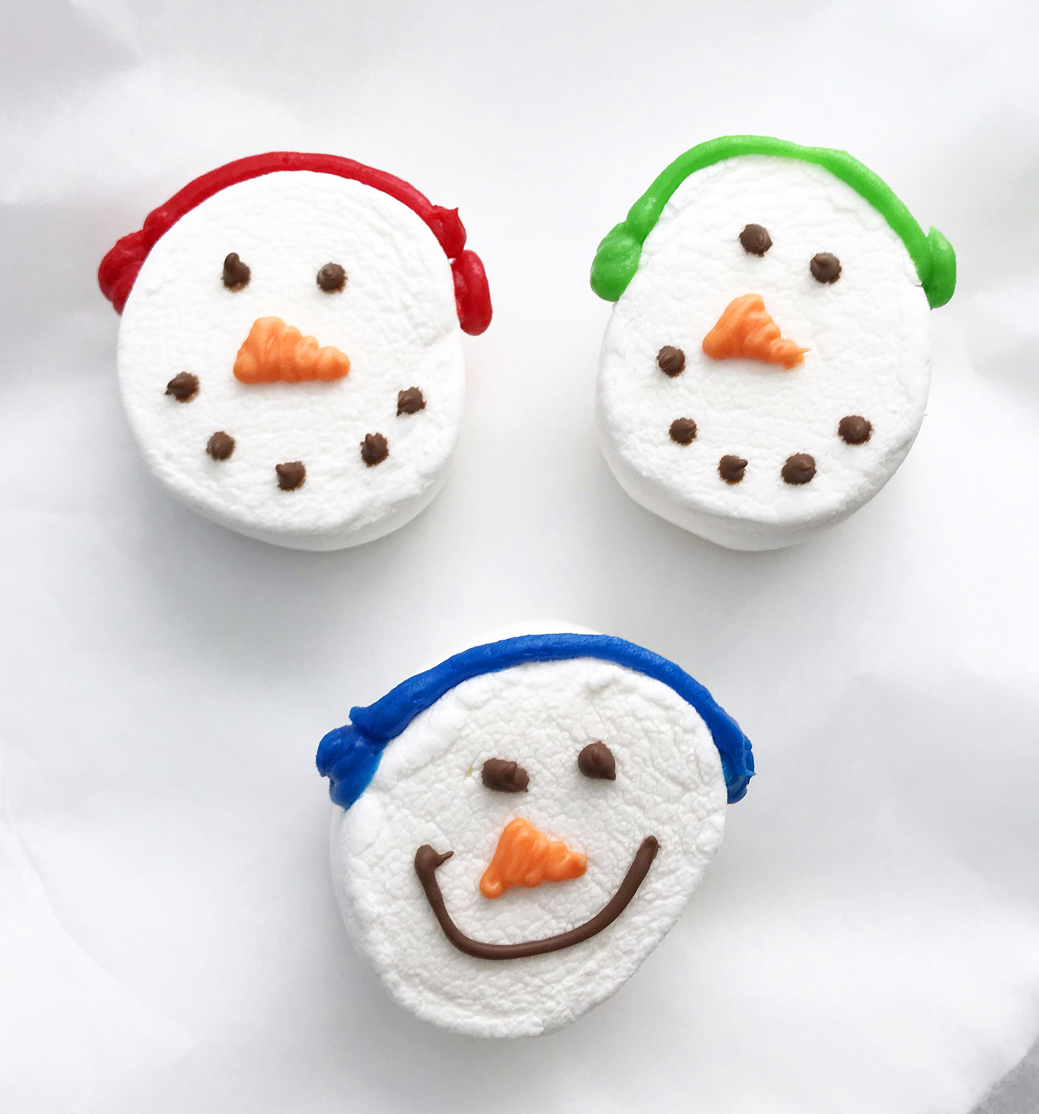 smiling snowman marshmallows wearing ear muffs