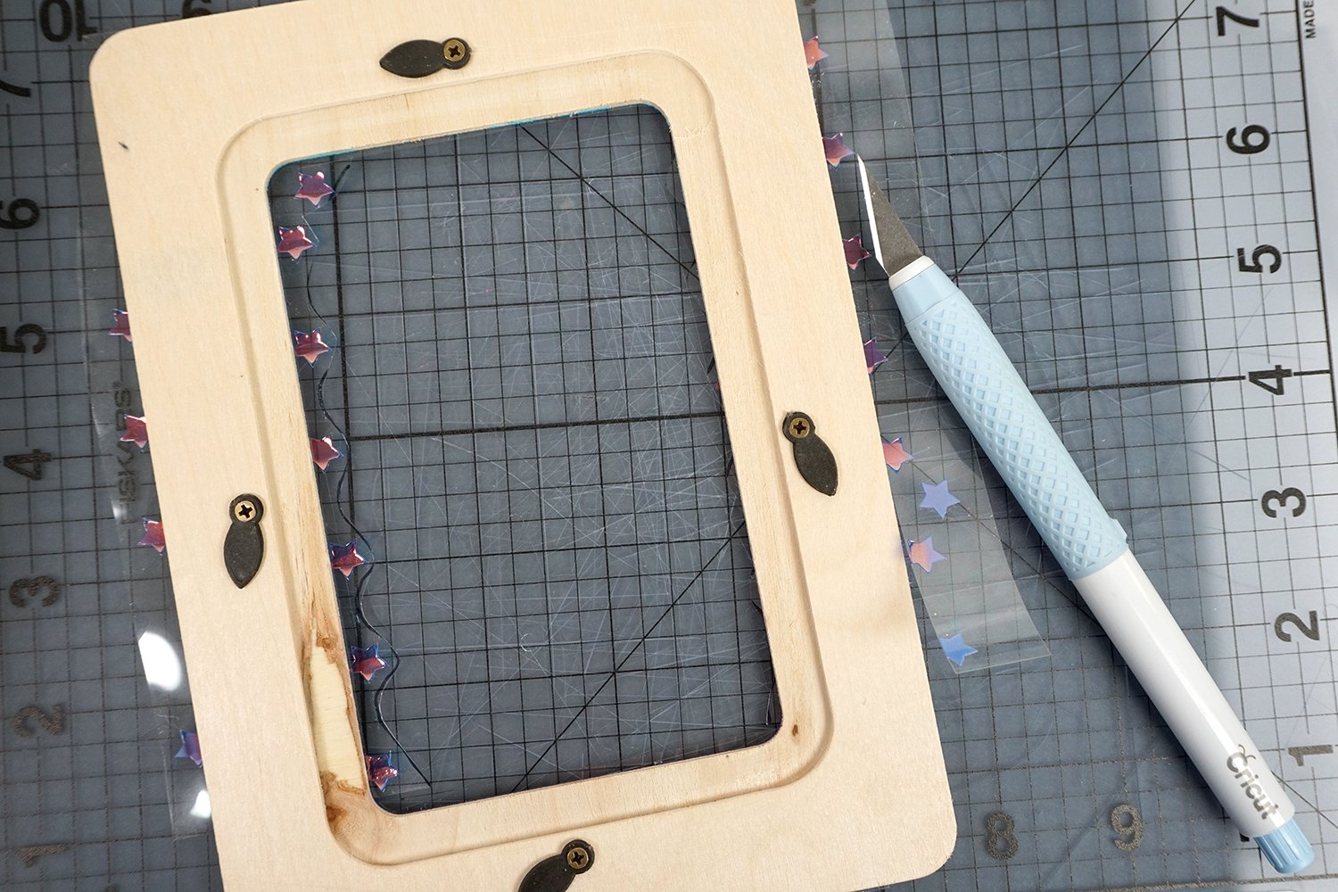 using cricut cutting tool to cut excess material on photo frame