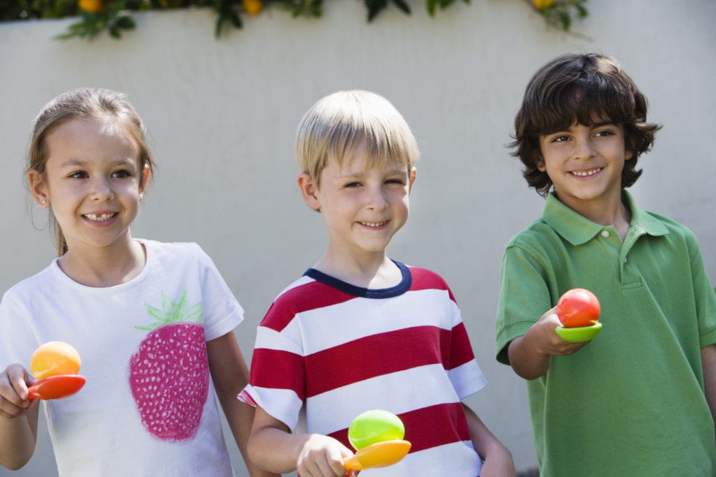 kids holding balls with spoons