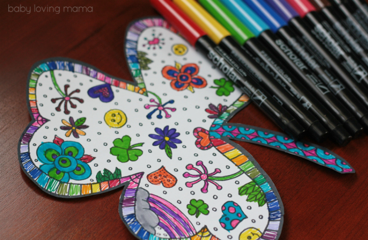 a wooden table topped with markers and a paper shamrock