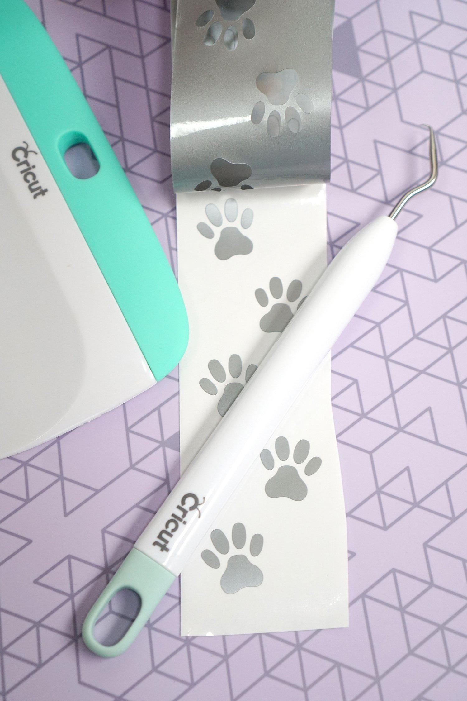 silver adhesive vinyl with paw prints and cricut tools