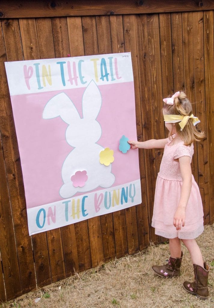small girl playing pin the tale on the bunny game