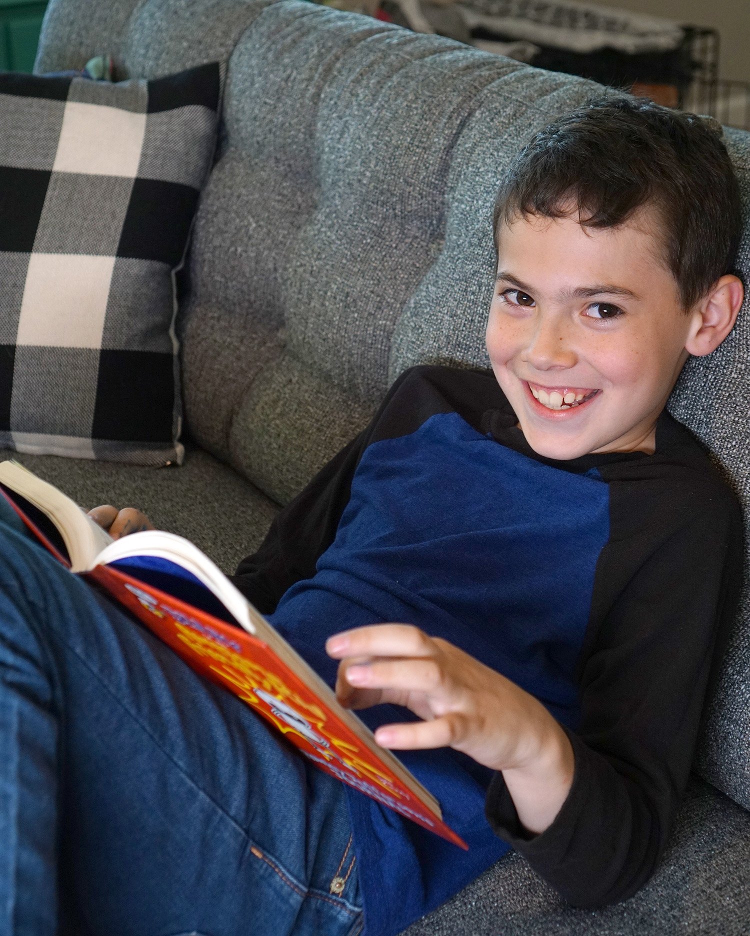 kid reading book on the couch