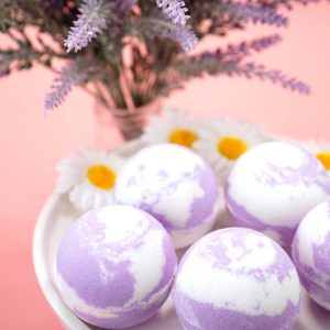 lavender and white bath bombs on a dish with lavender flowers in background