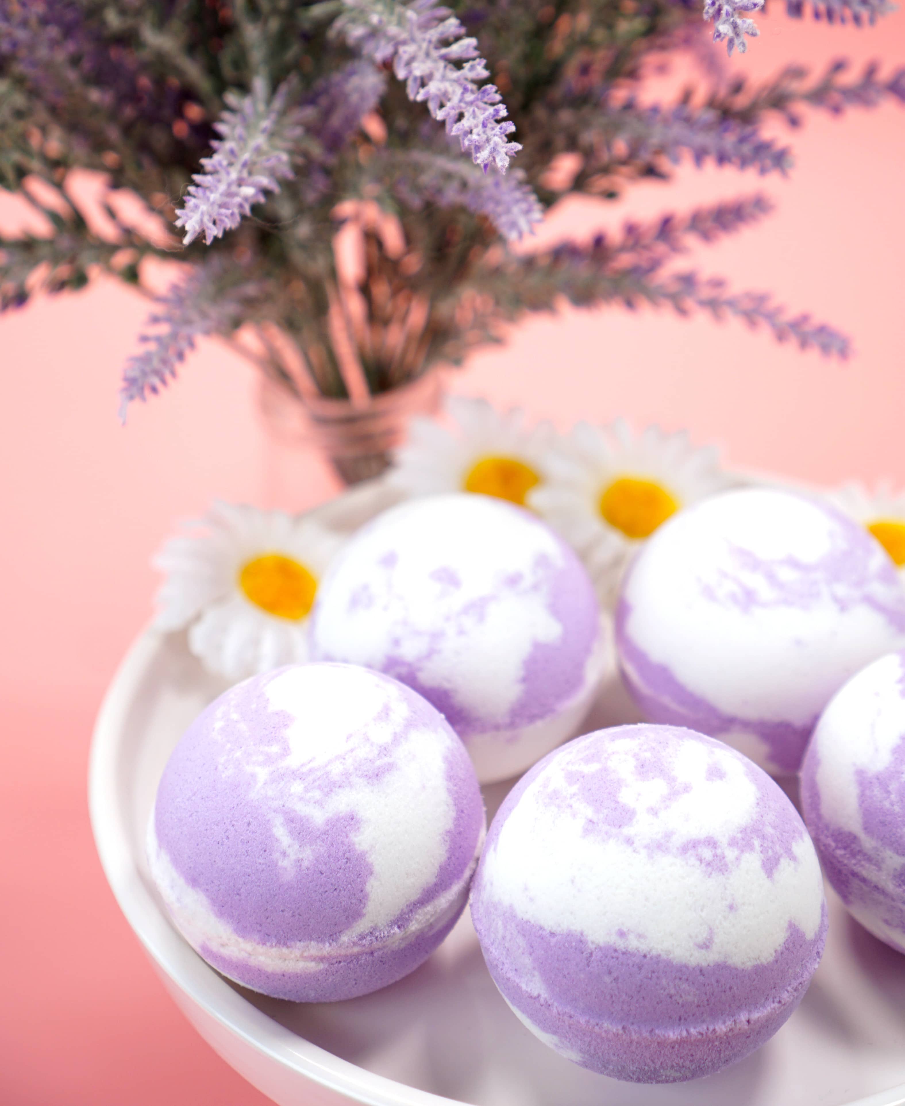 lavender and white bath bombs on a dish with lavender flowers in background