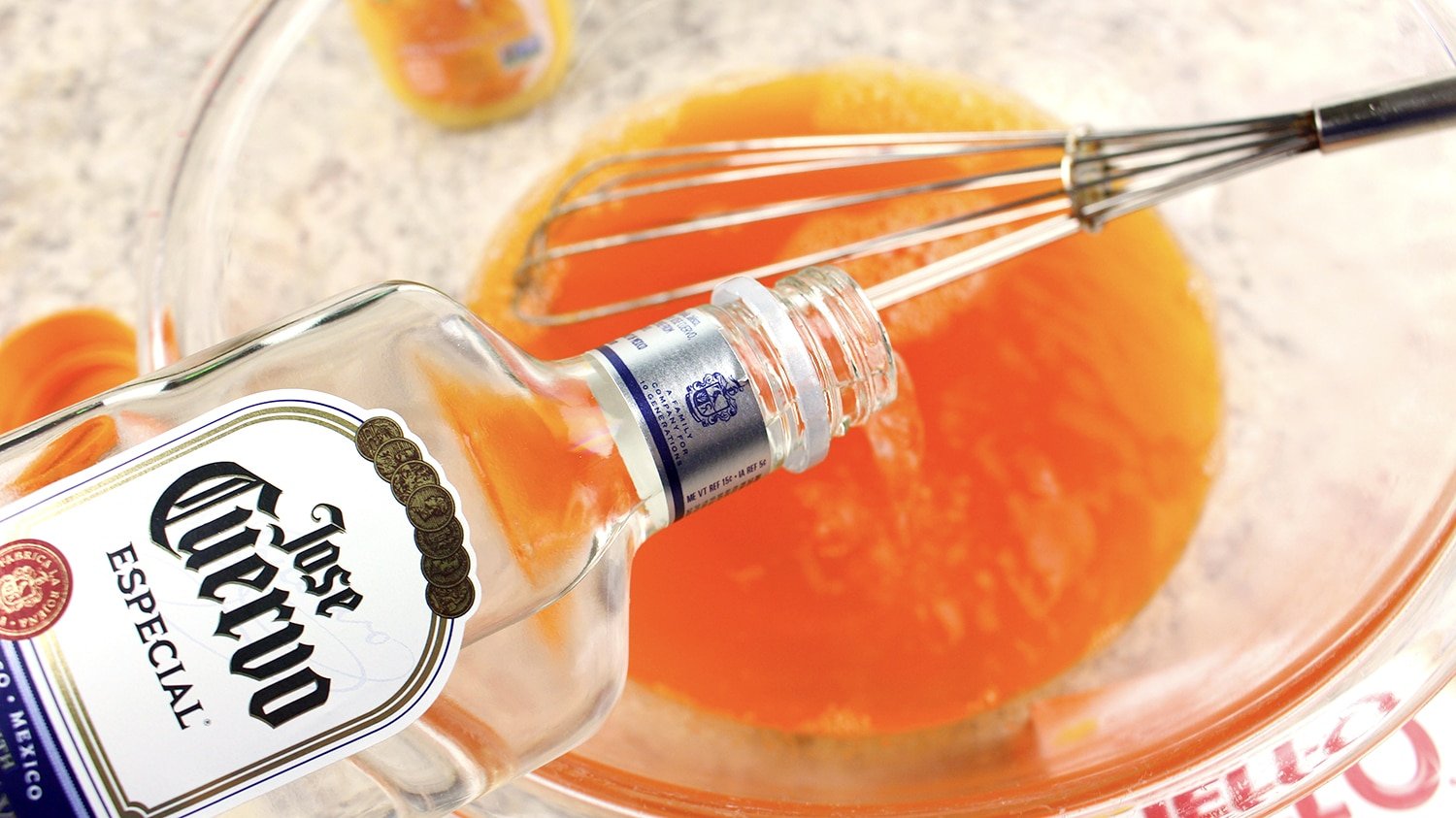 pouring tequila into orange mixture in bowl