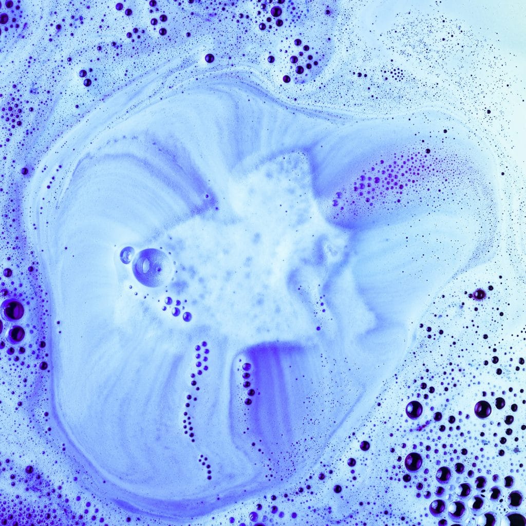 blue bath bomb fizzing in bath tub water