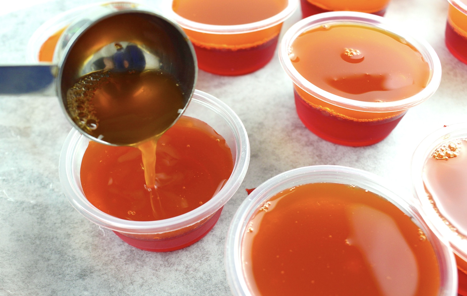 pouring second layer into the same individual jello shot cups