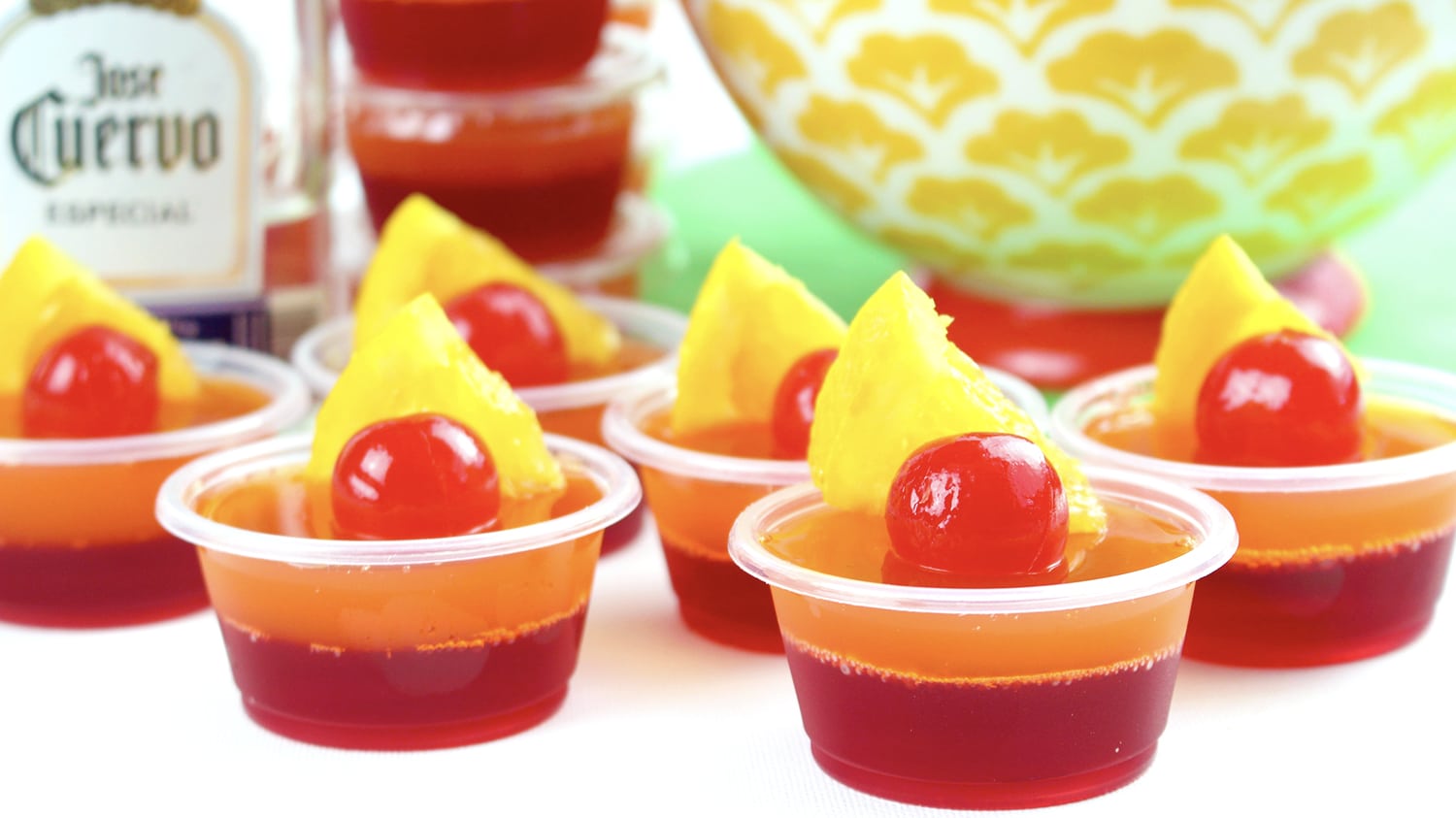 jello shots garnished with maraschino cherries and pineapple slices