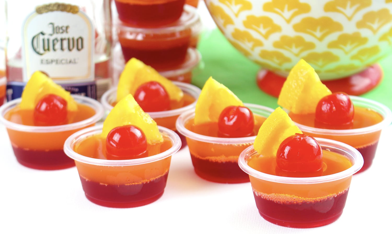 jello shots garnished with maraschino cherries and pineapple slices
