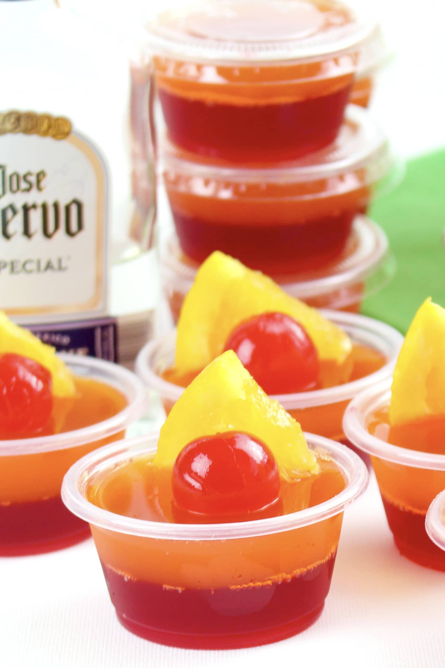 jello shots garnished with maraschino cherries and pineapple slices