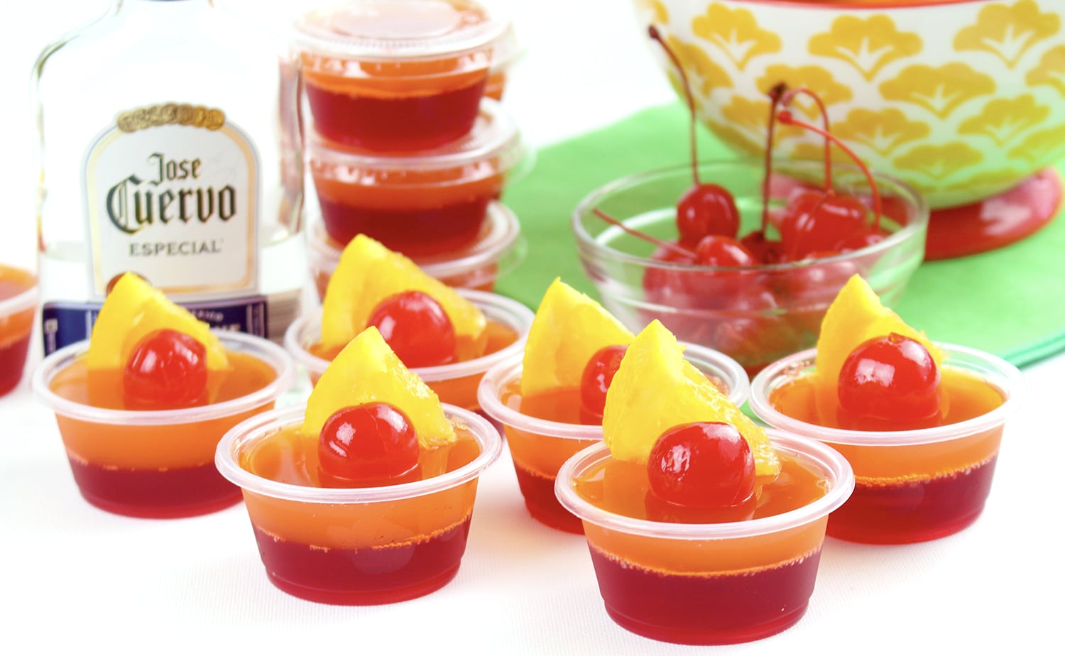 jello shots garnished with maraschino cherries and pineapple slices