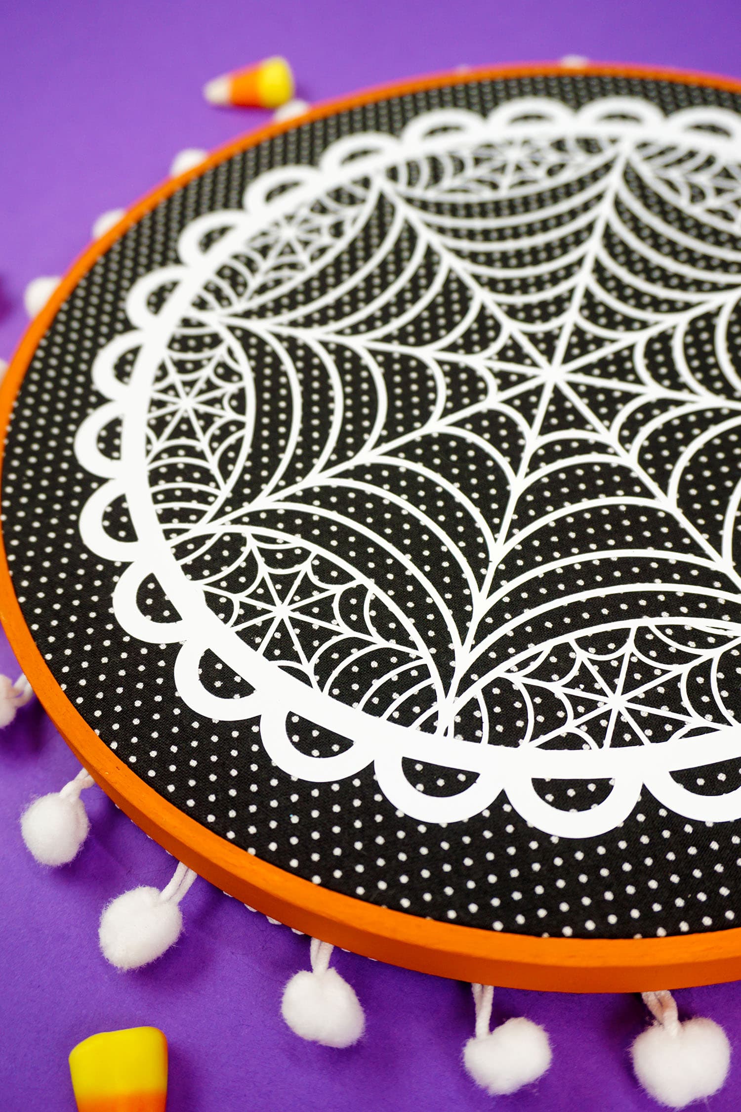 spider dangling from spider web embroidery hoop project