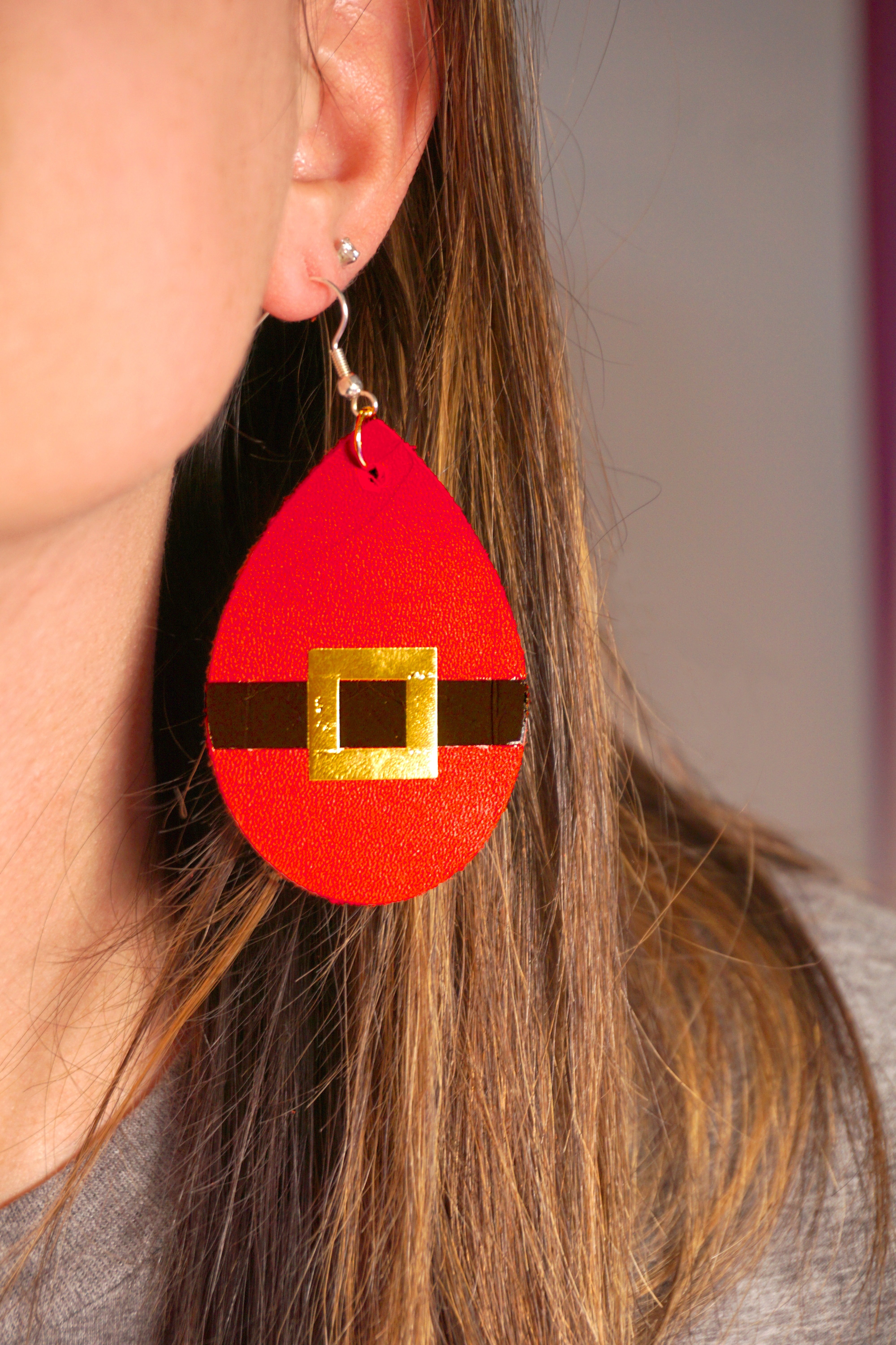 santa belt earring worn by woman