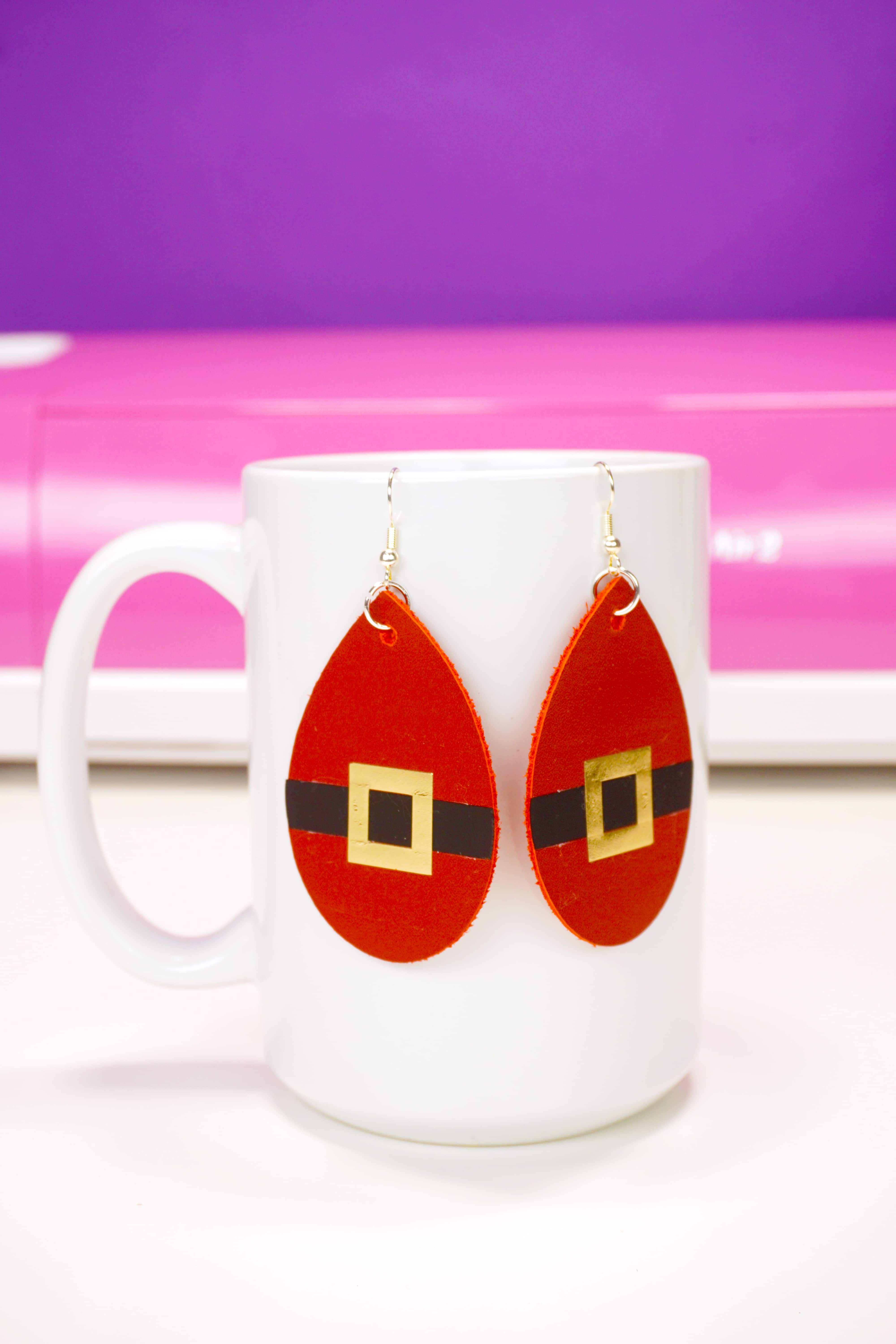 cricut cut santa belt earrings hanging on mug 