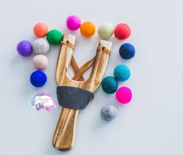 wooden sling shot with pom pom balls 