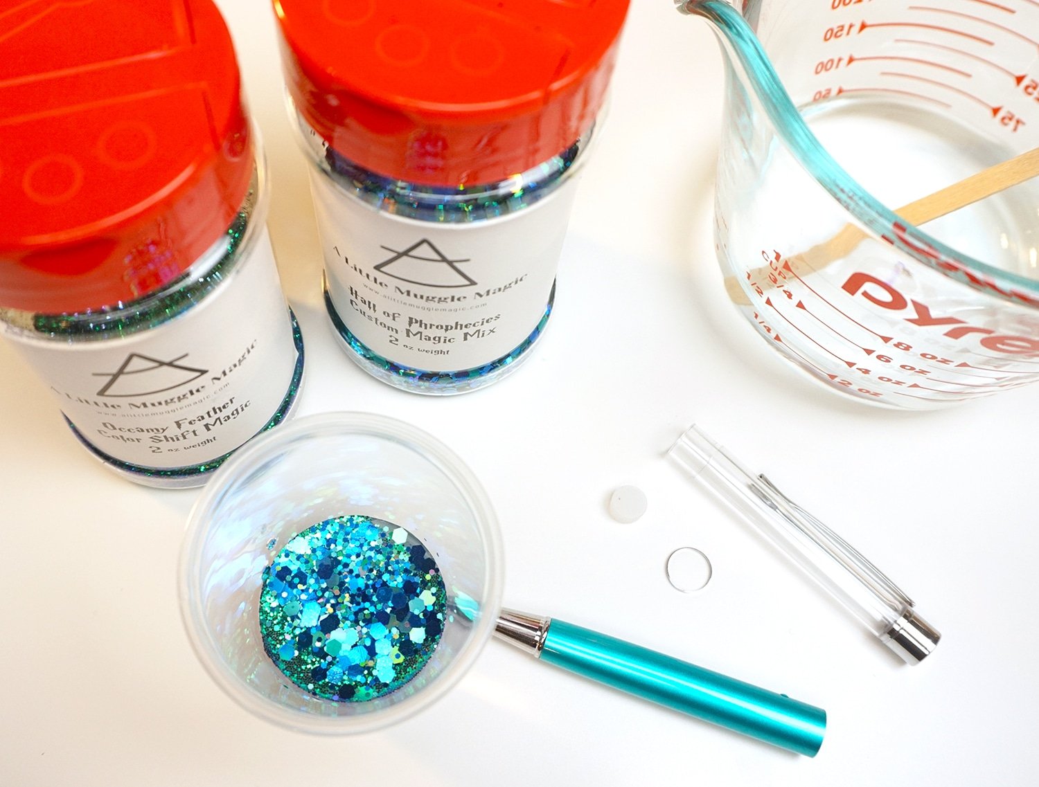 glitter in plastic cup and pen disassembled 