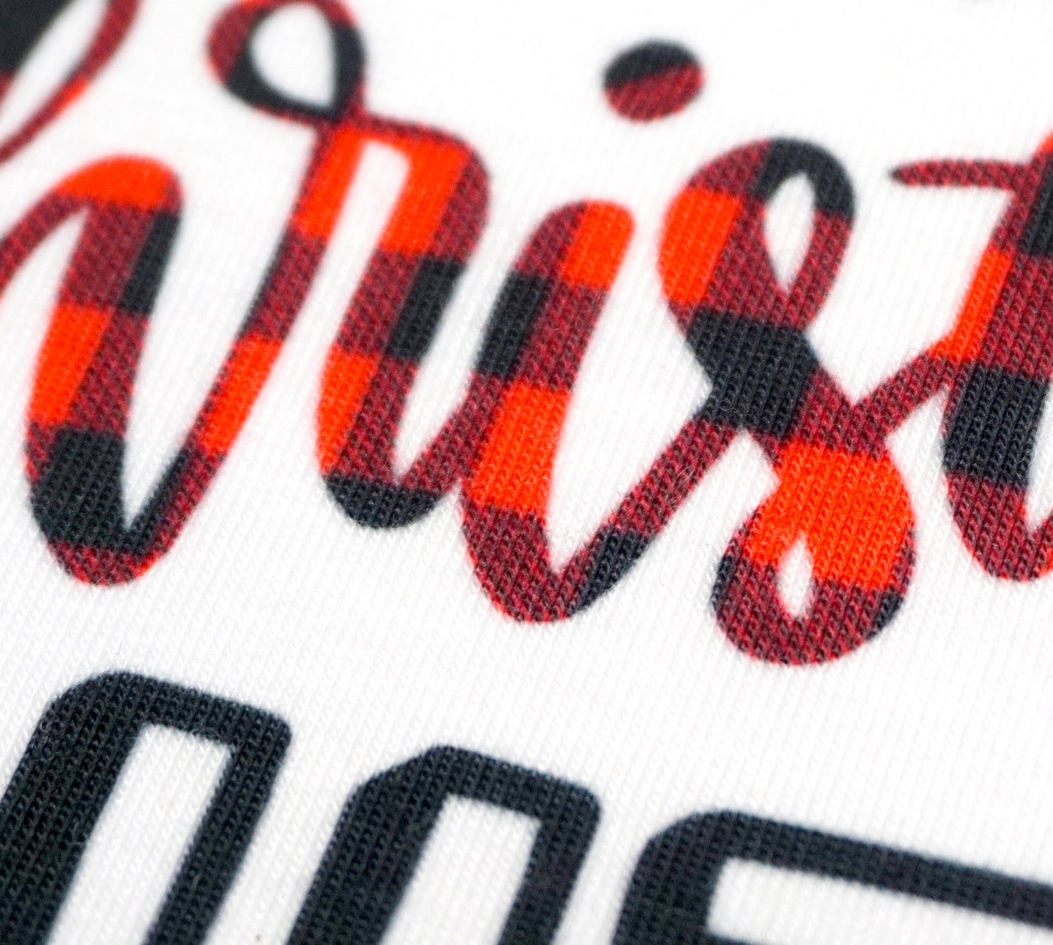 close up of infusible ink buffalo plaid christmas text on onesie