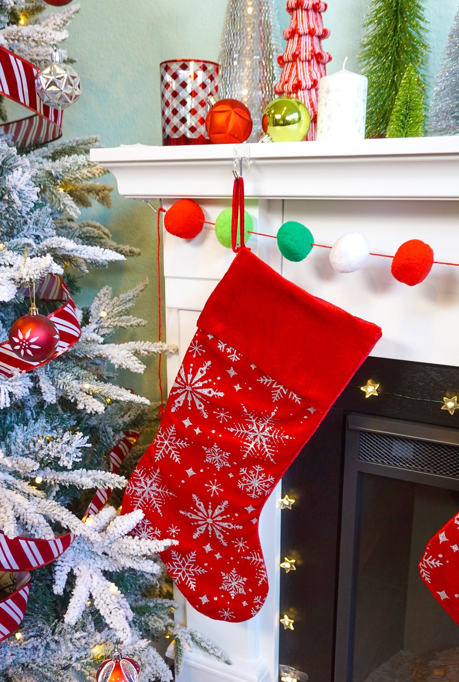 stocking and garland hung on mantel near christmas tree