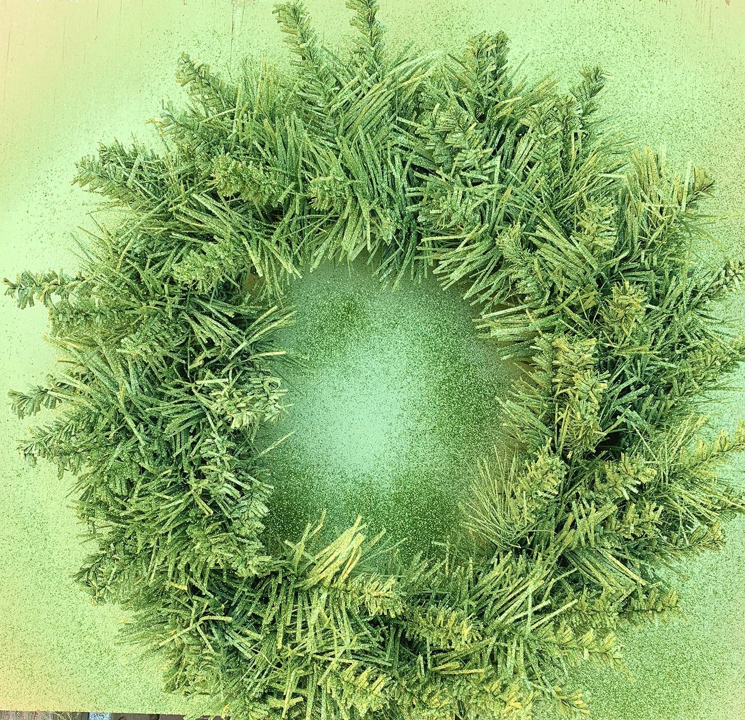 green faux wreath sprayed with glitter