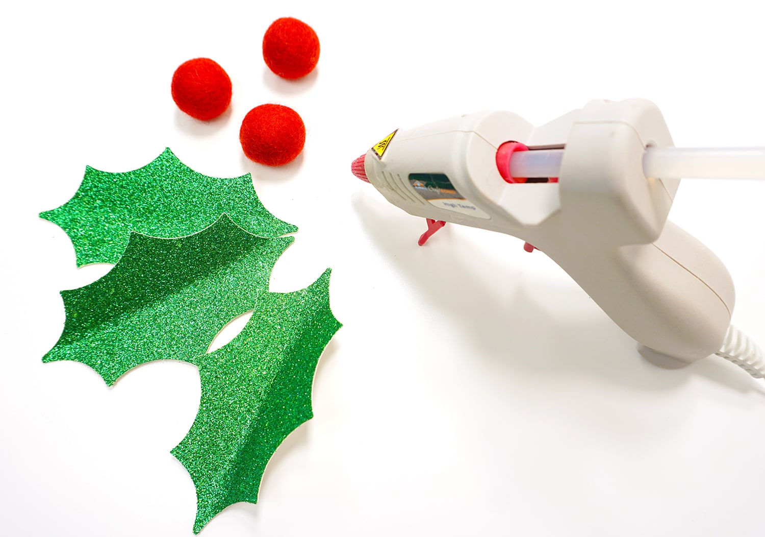 glue gun and holly leaves cut materials