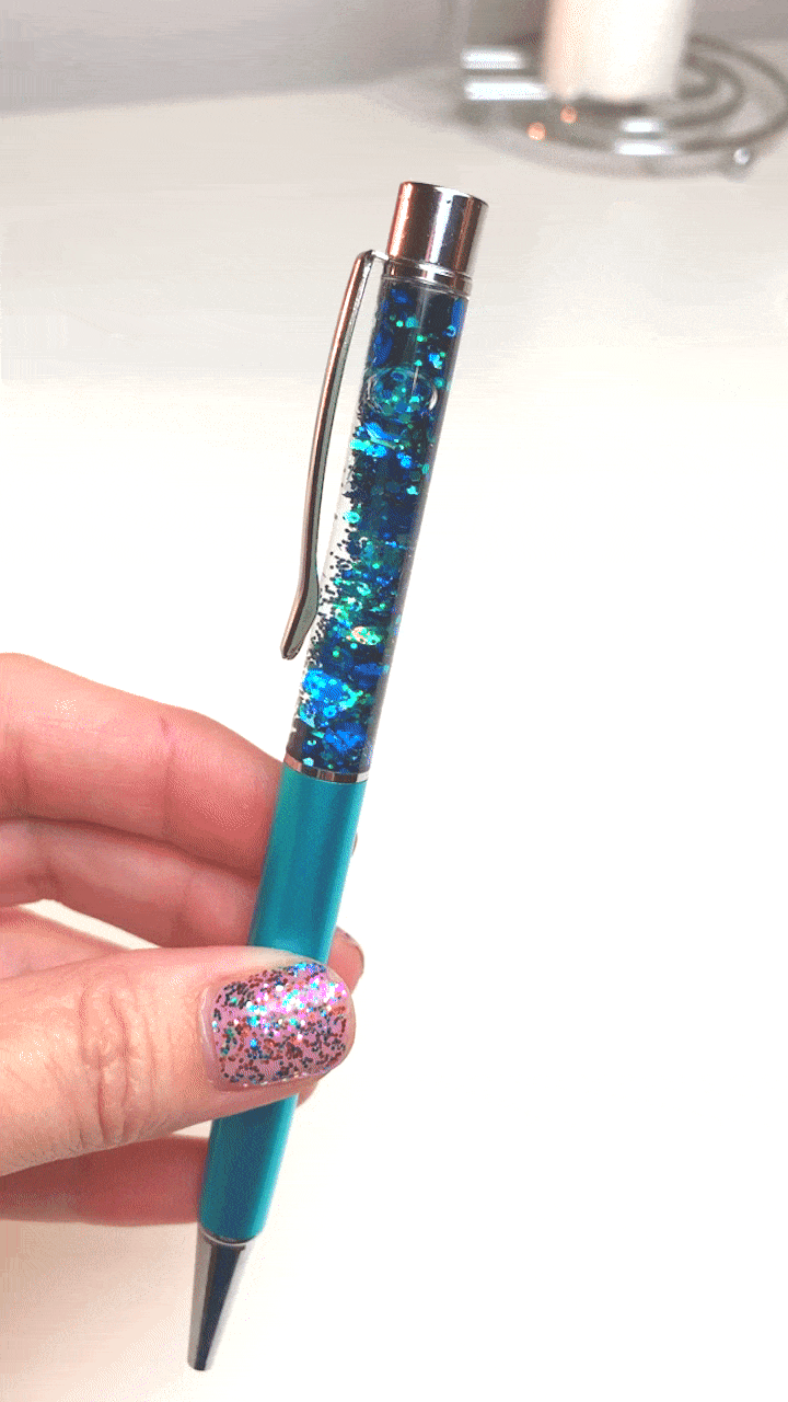 hand twirling blue DIY glitter pen in motion