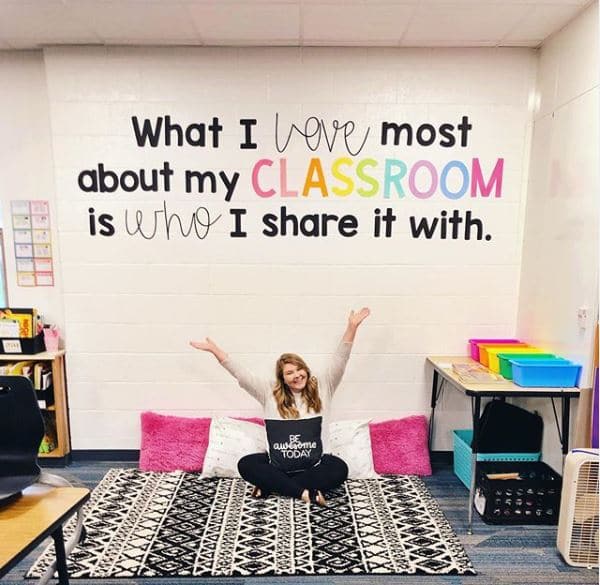 teacher sitting on floor in classroom