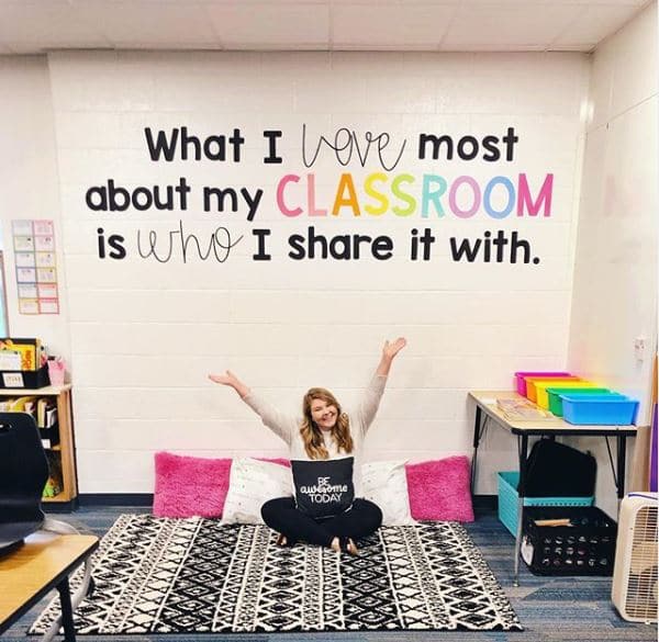 teacher sitting on floor in classroom 