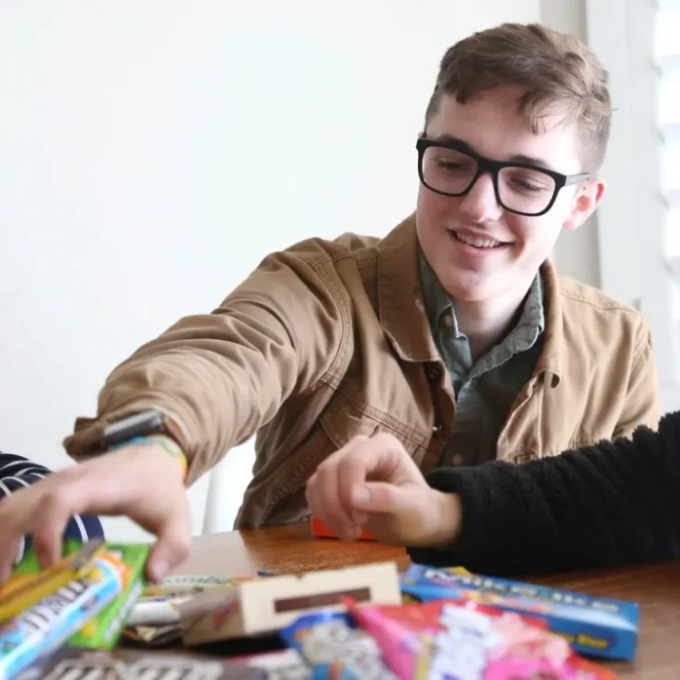 young man in glasses reaching for candy bars